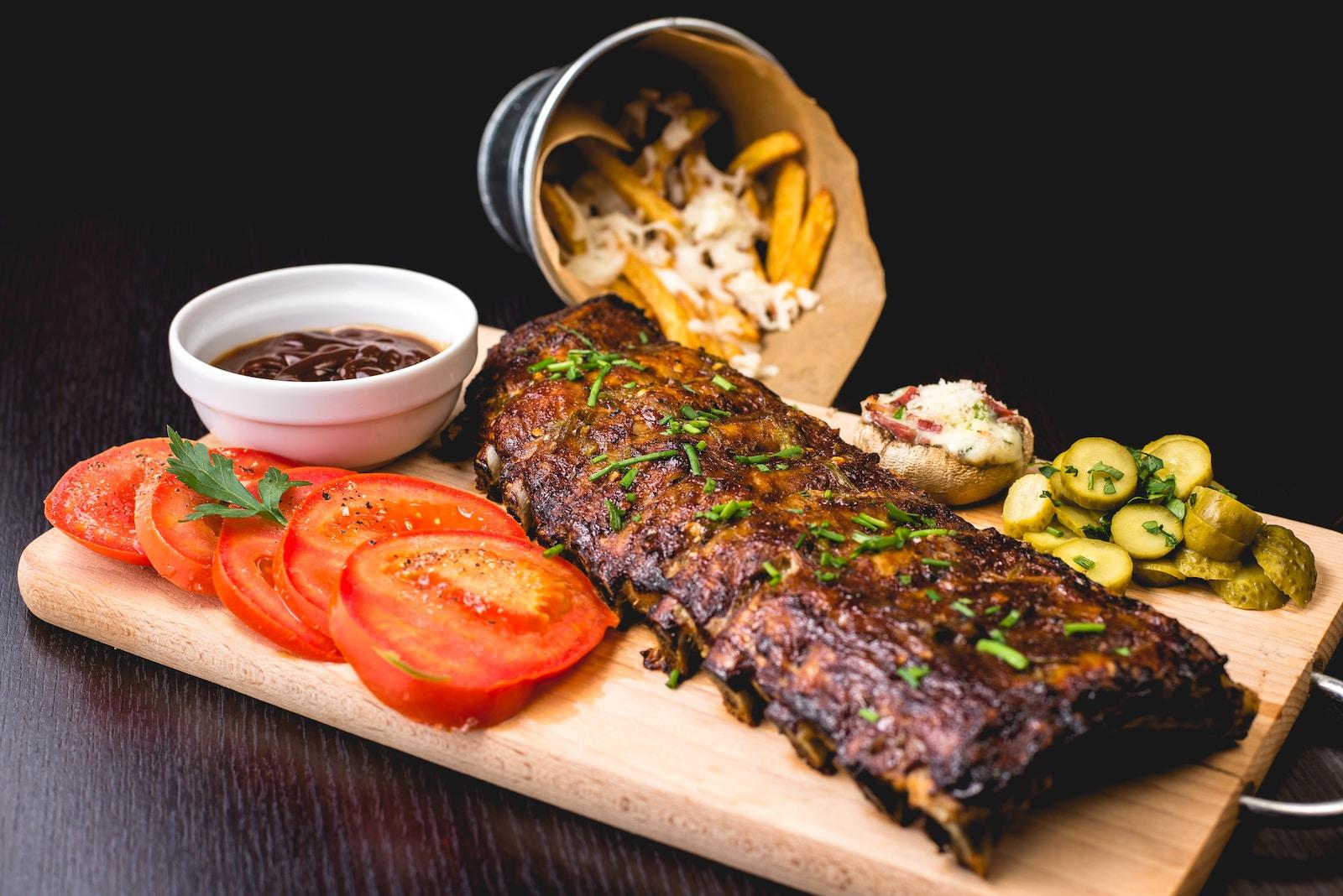 grilled ribs with sliced tomatoes and potatoes