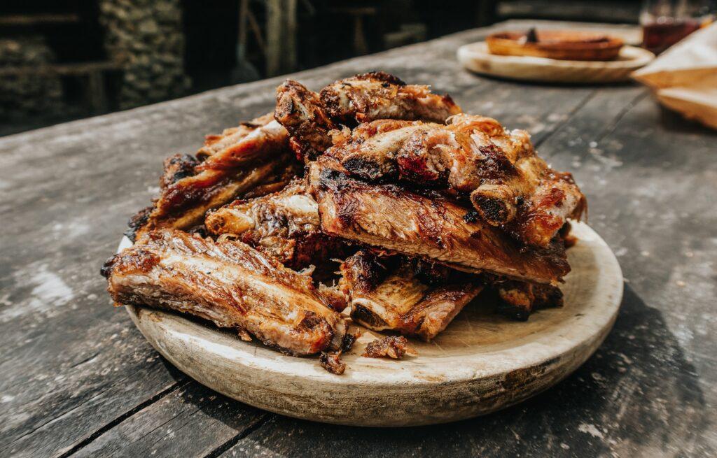 grilled bbq ribs on brown wooden tray